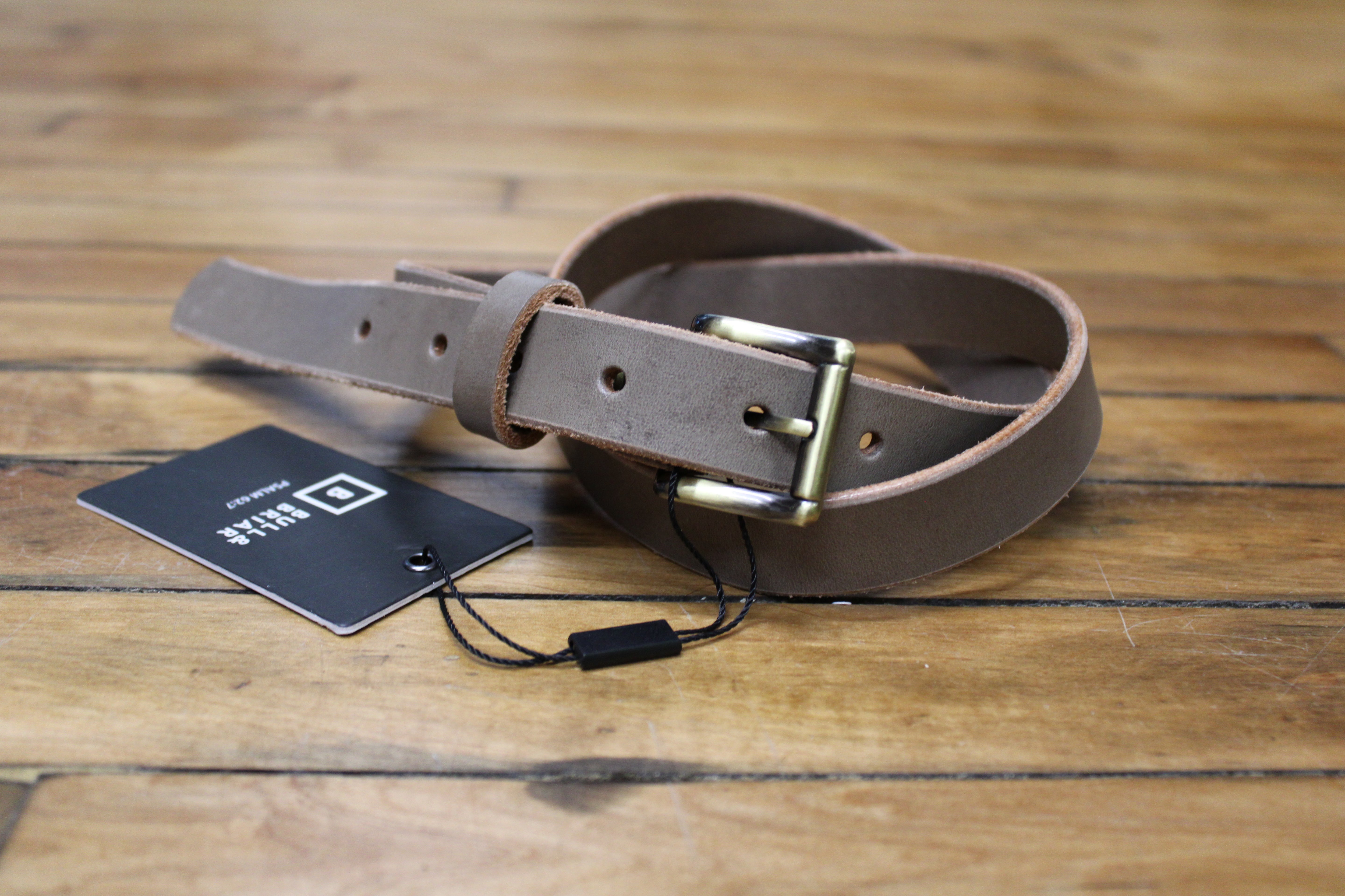 A grey leather belt with a buckle