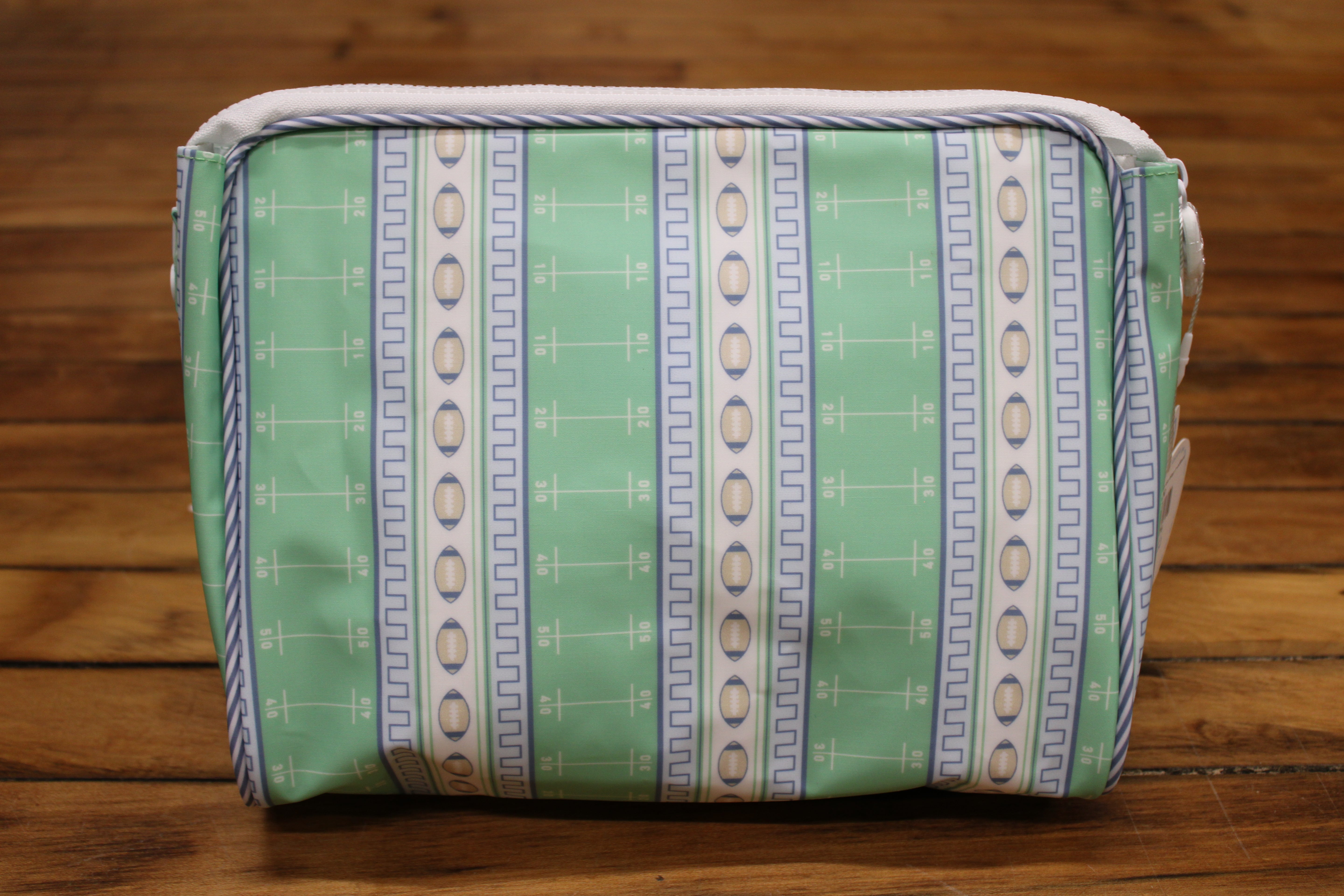 A rectangular zippered pouch with a mint green and white striped pattern featuring vertical bands of footballs and geometric motifs