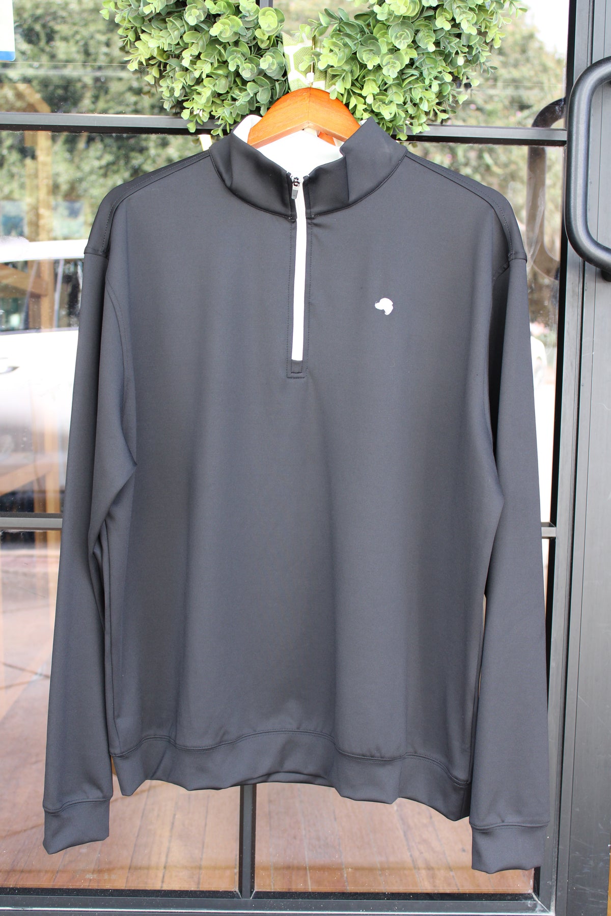 black quarter zip with silver zipper and dog logo on the left chest