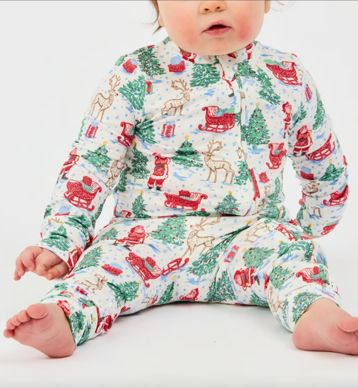 Baby wearing a Christmas-themed onesie on a white background