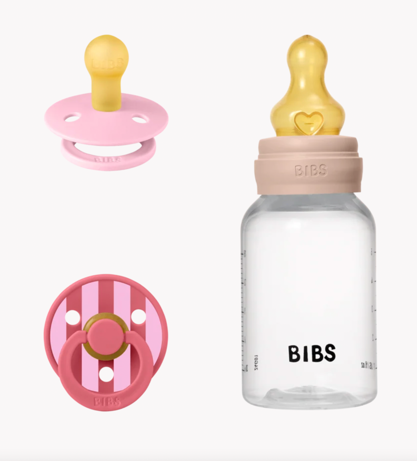 Bibs baby bottle and pacifiers on a clean white background. The set includes a clear bottle with a beige collar and a translucent yellow nipple, alongside a pink pacifier and a pink-and-white striped pacifier.