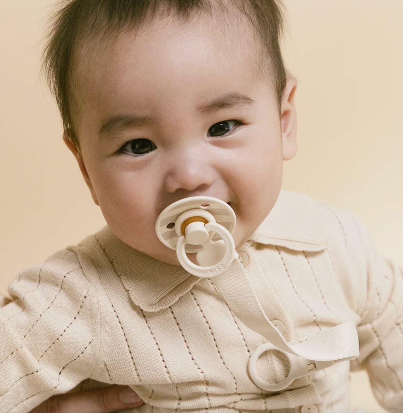 Baby with ivory pacifier and loop clip