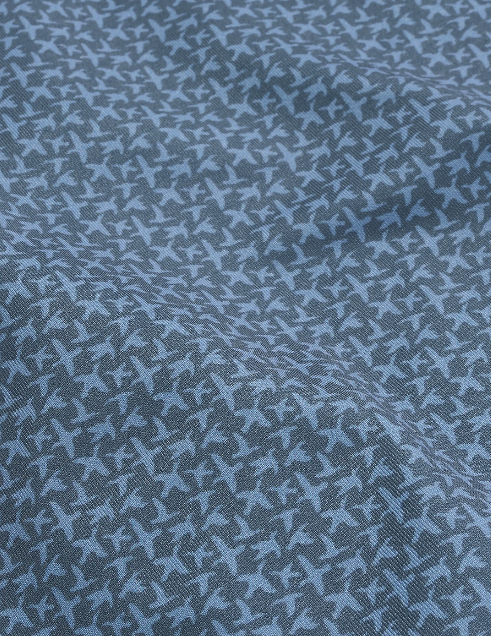 dark blue polo closer up with light blue bird outlines