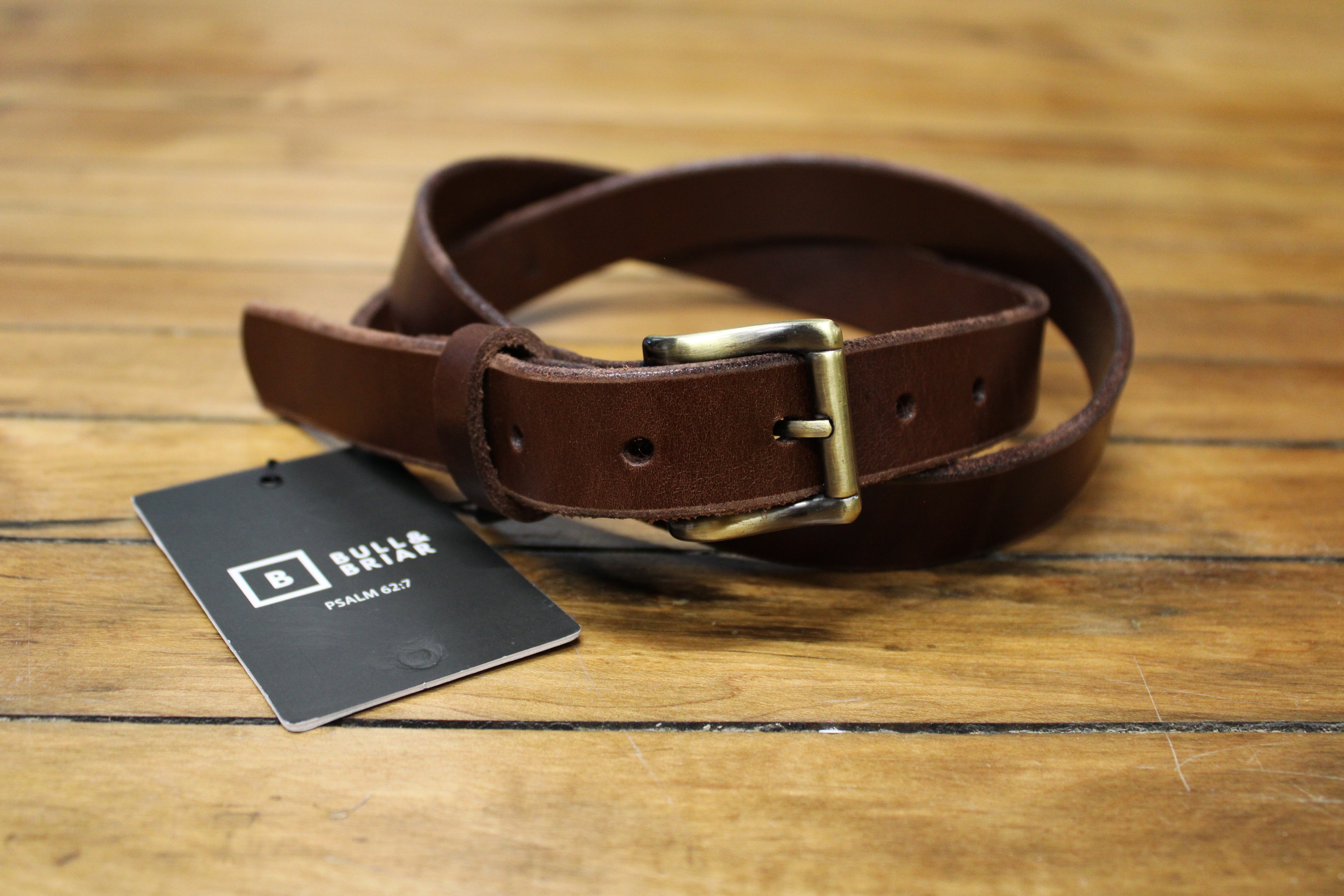 A dark brown leather belt with a buckle