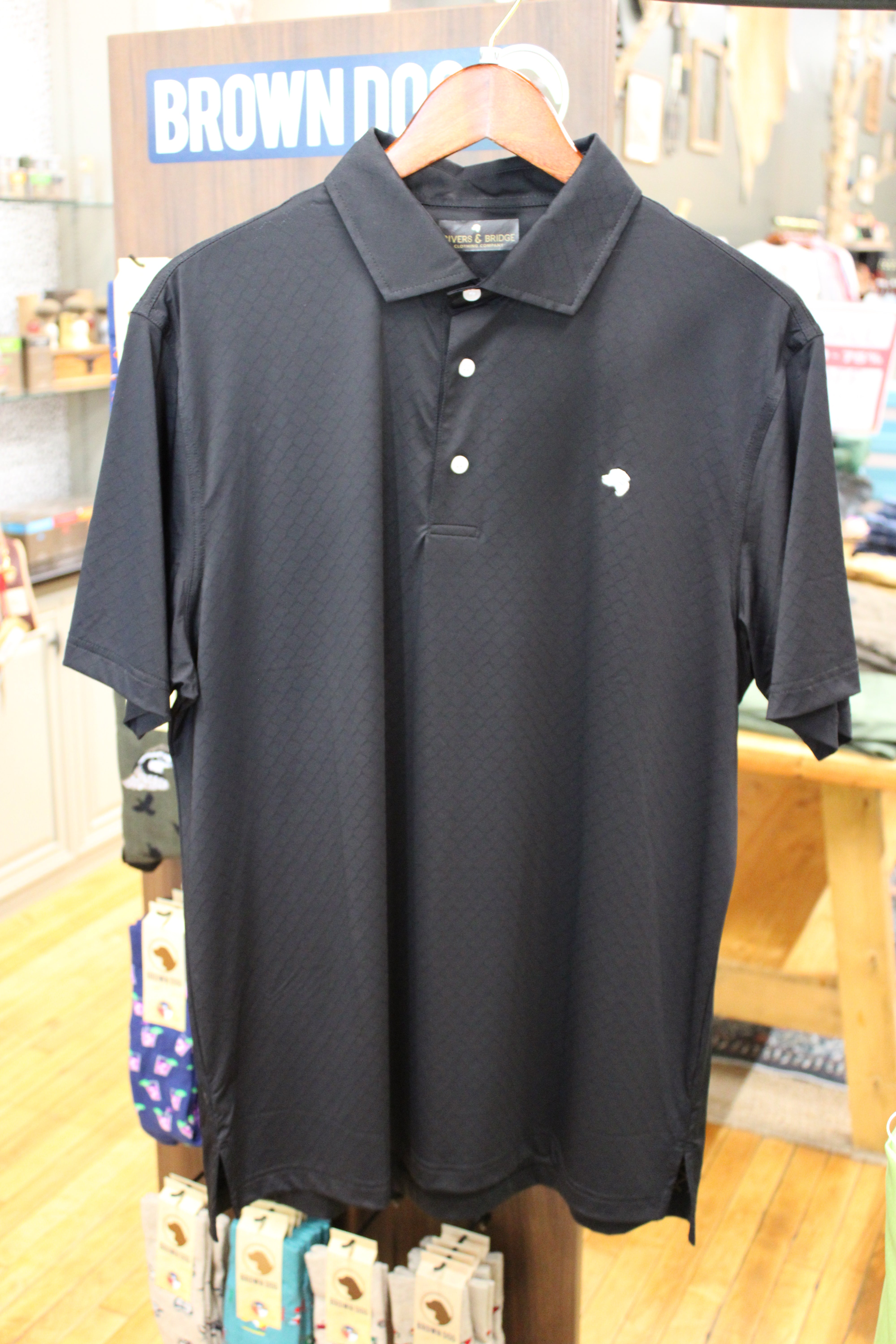 A black short-sleeve polo shirt with a small white embroidered logo on the left chest