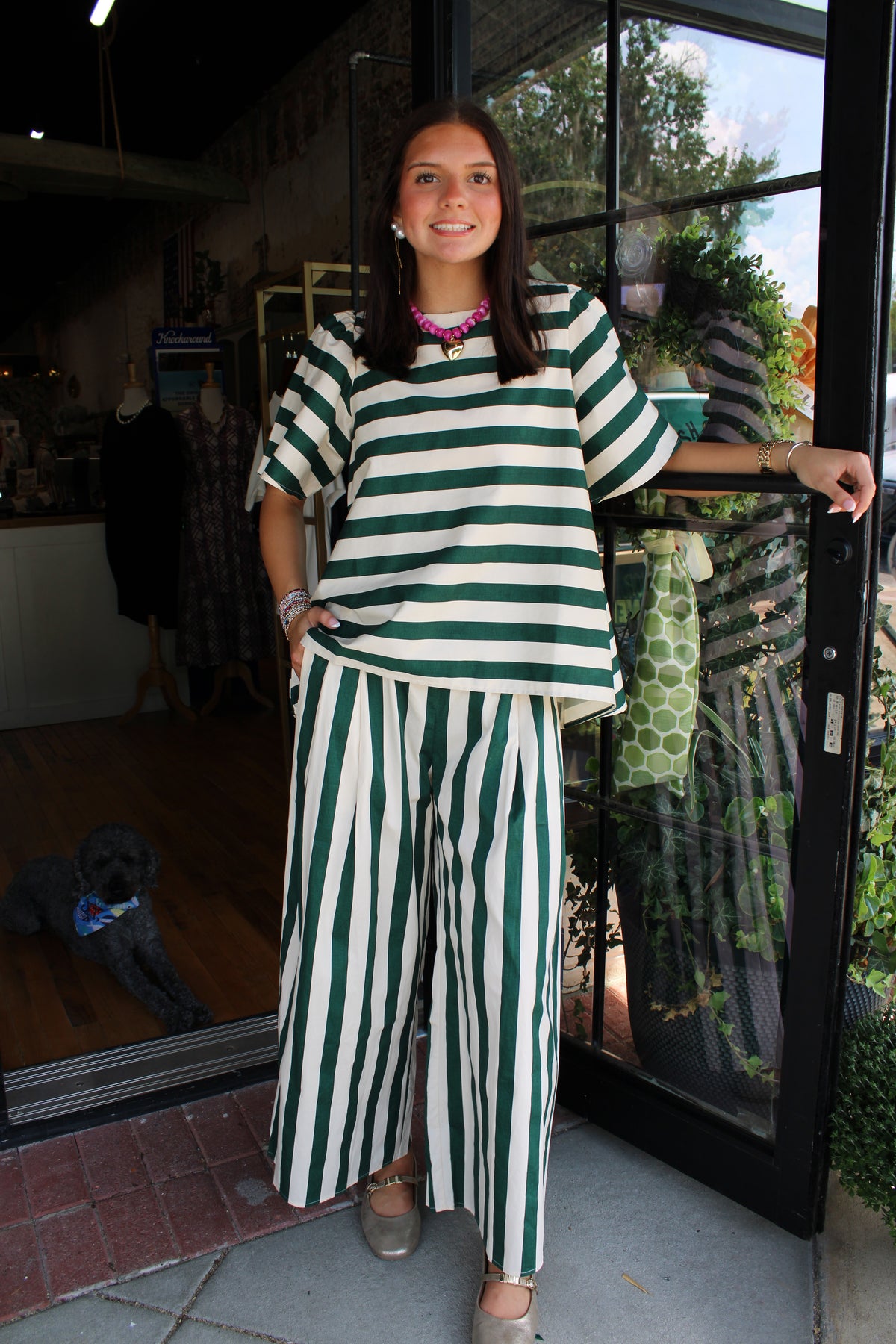 a woman wearing a green and white striped pant set
