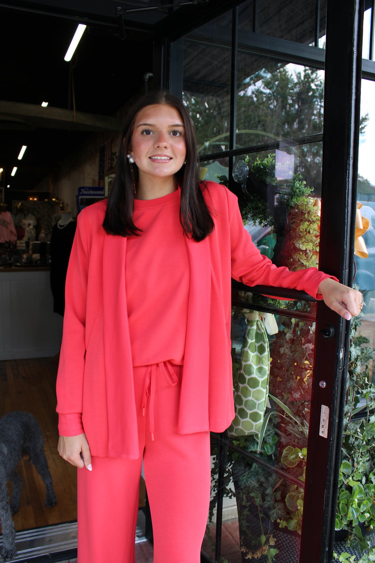 woman wearing red matching top, pant, and cardigan set