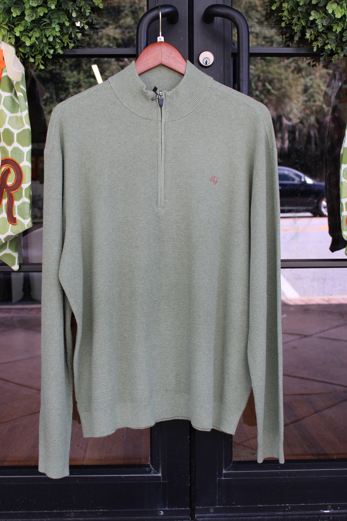 olive colored pullover with brown dog logo on the left chest