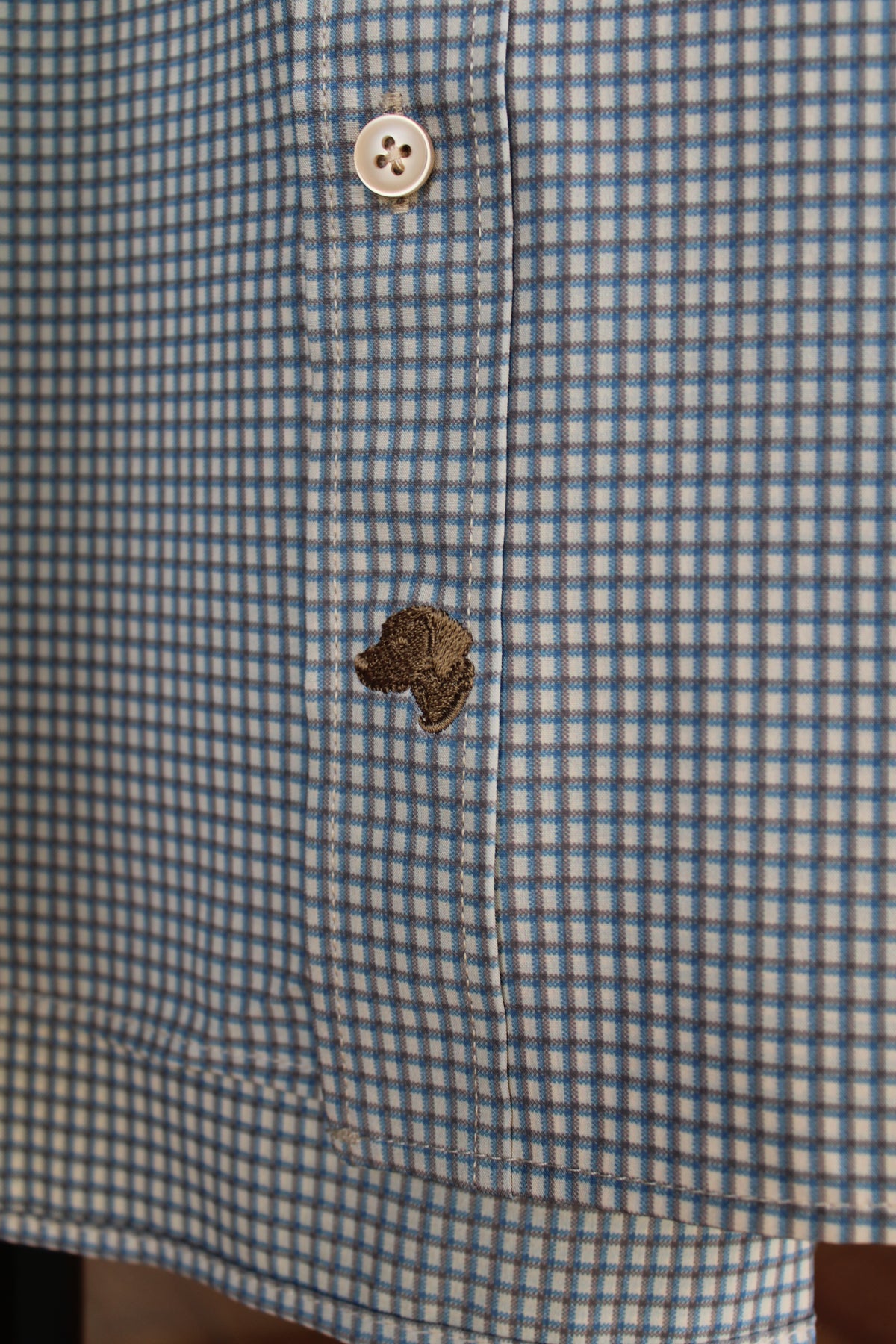 close up of a brown Rivers and Bridge logo on a mens button up shirt