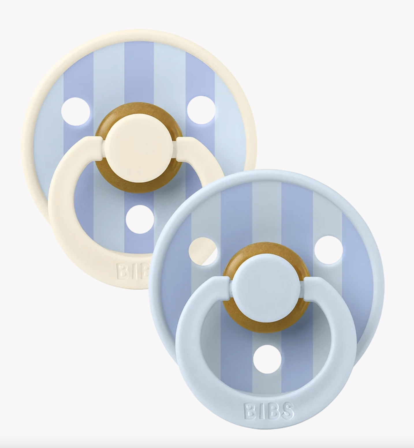 Two BIBS pacifiers with light blue and cream silicone rings, featuring light blue and blue vertical stripes on the shields with gold accents, shown on a light gray background.