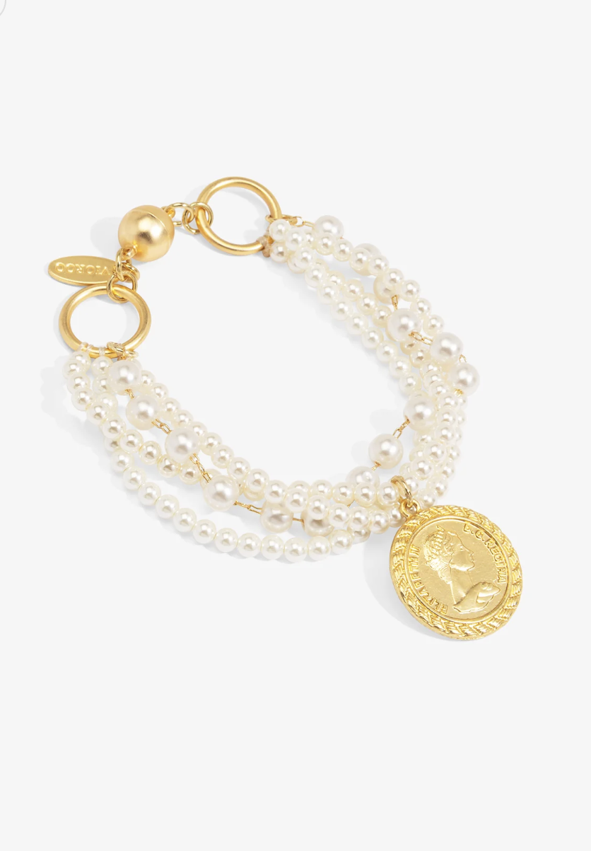 A gold-tone multi-strand pearl bracelet featuring a round gold coin pendant and a magnet clasp, displayed on a clean white background.