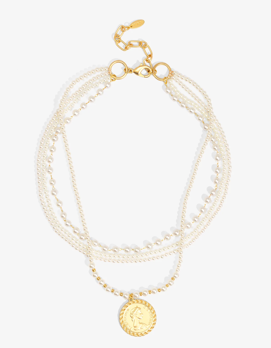 A multi-strand pearl necklace with gold-tone chains, a lobster clasp, and a round gold coin pendant featuring a profile portrait, shown on a light gray background.