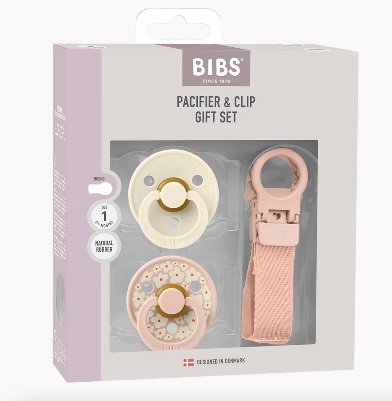 BIBS pacifier and clip gift set in its original packaging, featuring a cream-colored pacifier, a pink pacifier with flowers, and a matching pink clip on a light gray and lavender box.
