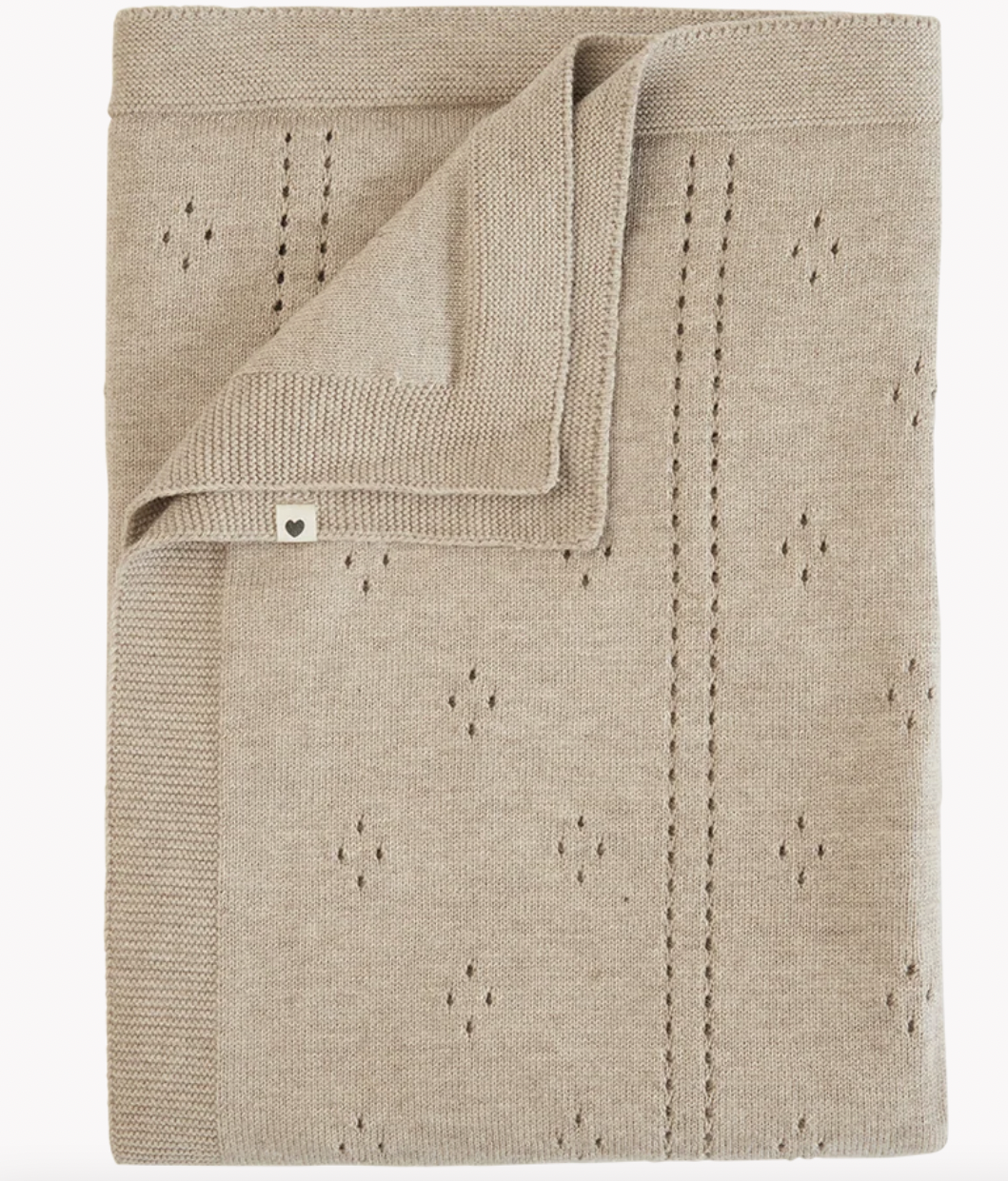 A folded knit blanket in a light oatmeal beige color, featuring a subtle knit pattern with small diamond motifs and a folded corner showing the reverse side.