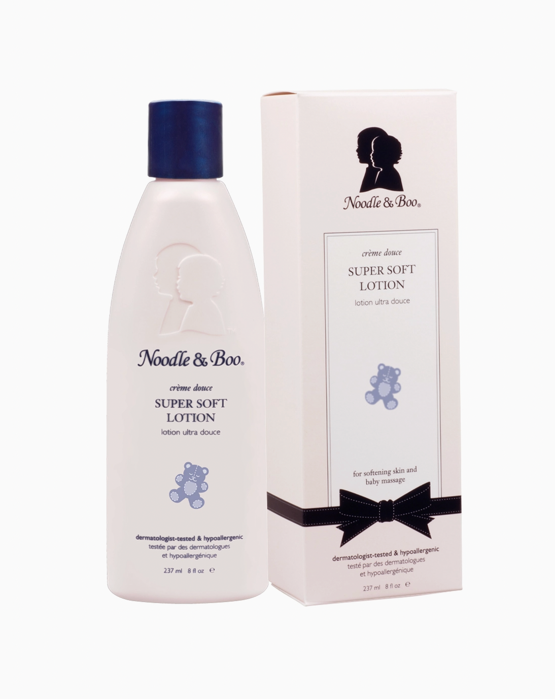 Noodle & Boo Super Soft Lotion bottle in cream with a dark blue cap, shown next to its white packaging box featuring a black silhouette logo, teddy bear illustration, and a black ribbon graphic.