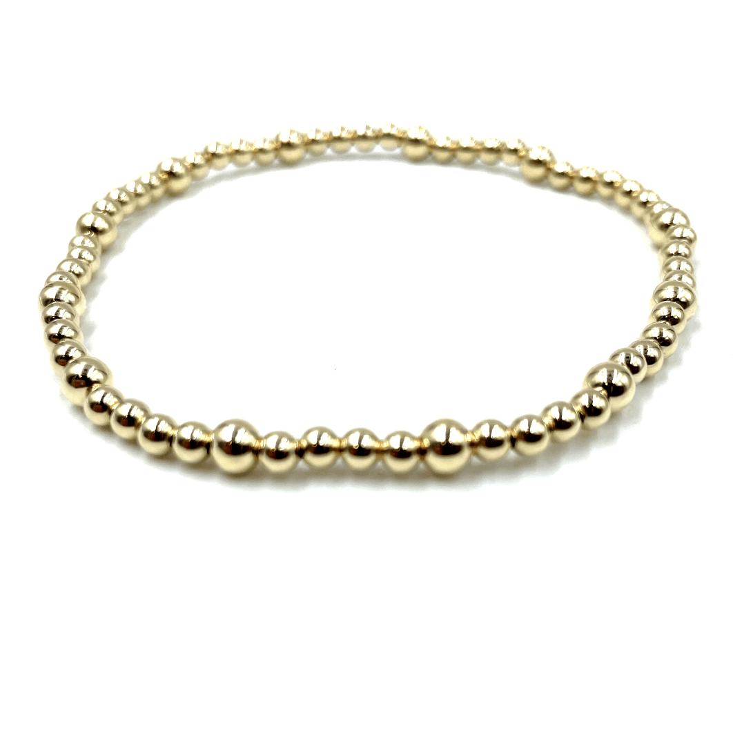 Gold-filled stretch bracelet by Erin Gray. The bracelet is gold beads around and has a pattern of a 4mm bead, then four 3mm beads all around. 